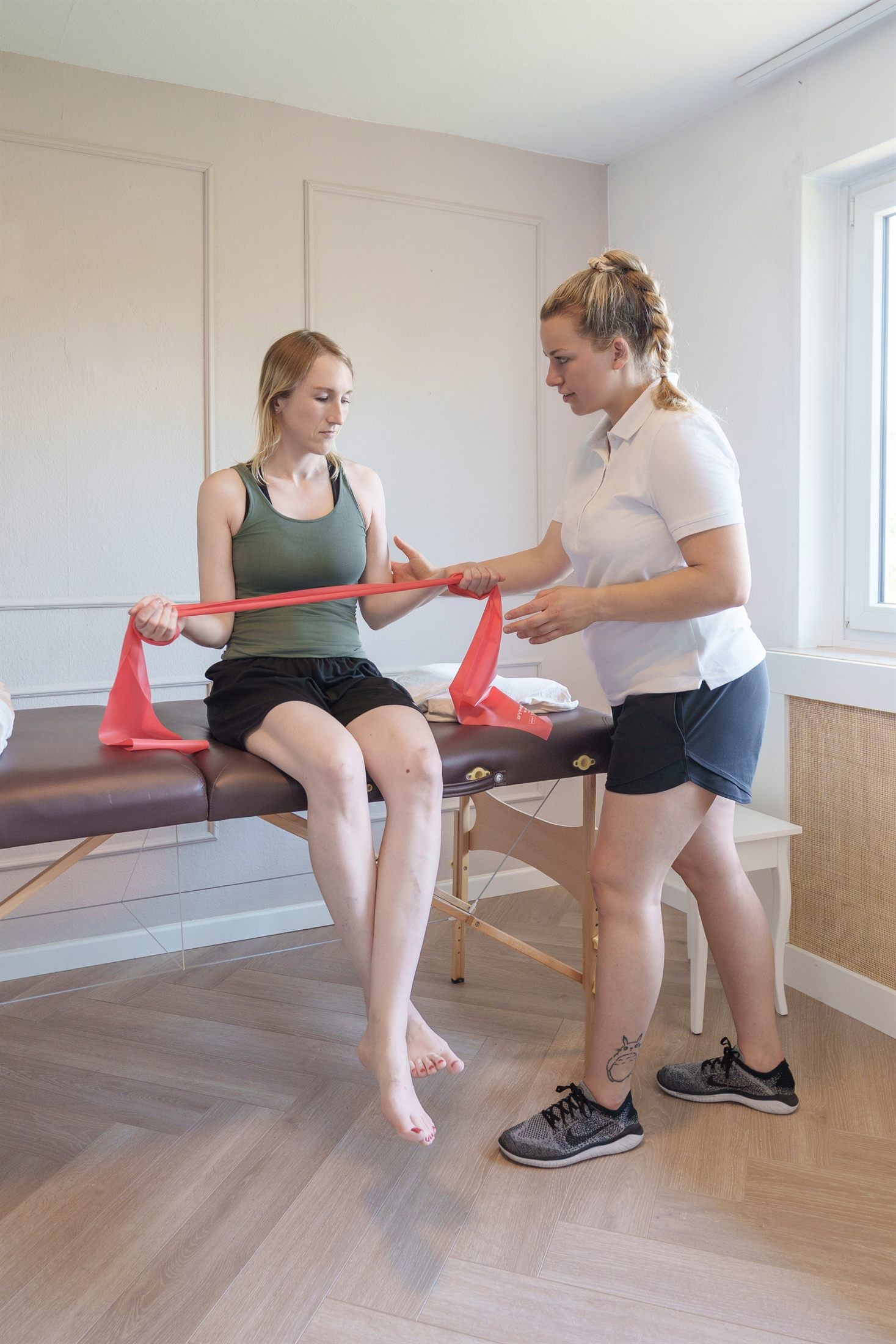 Krankengymnastik-Übung mit Therapieband im Sitzen